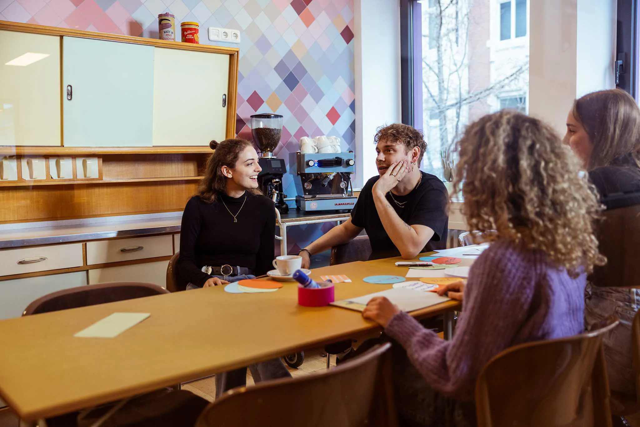 Drei Menschen sitzen am Tisch